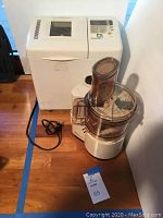 Overview of the Regal La Machine food processor and Toastmaster Platinum bread machine side by side on floor.