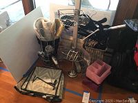 Photo showing various bathroom accessories including metal stands, hair dryer, hangers, and rugs