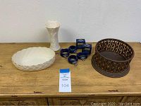 Wide shot showing all items: white vase, oval server, bowl, napkin rings in boxes, and wooden basket
