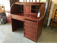 Front view of desk open showing tambour roll top open, central cubby with cabinet and side shelves, left shallow drawer and right four drawers