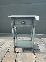 Front view of the gray side table showing the drawer and bottom shelf