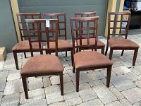 Six brown wooden dining chairs arranged in two rows on a stone patio, showing front and top views.