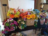 Overview of six faux flower arrangements in various planters and vases, showing colors and styles.