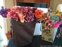 Two bags filled with assorted faux flowers on a table