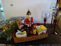 Santa music box, nutcracker figurine, ceramic containers, and wicker basket arranged on table