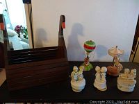 Overall view of the wooden duck magazine rack and the collection of music box figurines including the hot air balloon on the right side.