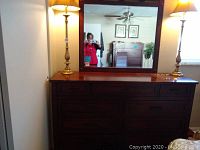 Full view of the dresser with the mirror on top and two lamps, showing the style and condition.