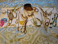 Full view of the jewelry collection including necklaces, bracelets, and a brown leather belt.