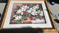 Framed print of white flowers and fruit showing the ornate gilt frame and full artwork.