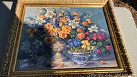 Full view of the floral print in the heavy giltwood frame, showing vibrant colors and detailed flower pots.