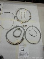 Full view of all jewelry pieces included in the lot laid out on a flat surface showing necklaces, bracelets, and earrings.