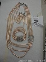Photo showing the complete pink pearl costume jewelry set including necklace, bracelet, and earrings laid flat with lot identification placard.