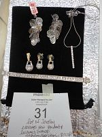Photo showing new silver earrings, pendant necklace, gold-tone earrings, and sterling vermeil bracelet arranged on black display with auction lot tag.