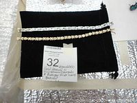 Two bracelets displayed on black cloth: a heavy sterling silver bracelet and a more delicate gold vermeil bracelet with diamond accents