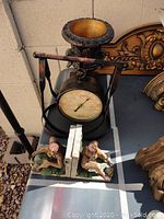 Decor items including bronze thermometer, monkey bookends, bronze lamp, and vase on table