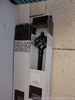 Two boxed curtain rods showing the rod finials and packaging including brand name and size.