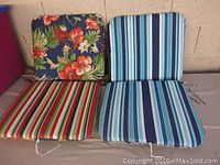 Four chair pads laid out showing different floral and striped patterns