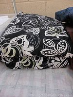 Folded twin bedspread showing the large floral pattern with black, white, and lime green colors