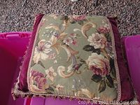 Photo showing one large euro size down filled pillow with floral patterned front panel in jewel tones, deep purple velvet border, and tassel fringe trim on a carpeted floor.
