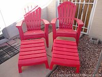 Two red Adirondack chairs with matching red footstools arranged on a patio.