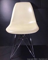 Front facing view of beige plastic shell chair on chrome Eiffel style wire base.