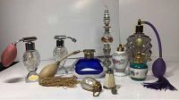 Wide view showing nine antique and vintage perfume and snuff bottles, varying colors and styles including cobalt blue crystal, smoked glass, porcelain, and mother of pearl.