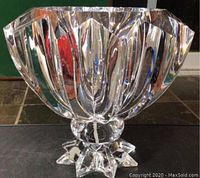 Side view of a clear Lucite pedestal art bowl showing the faceted grainware pattern and star-shaped base.