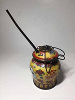 Front view of porcelain jar with mounted lid, pipe inserted, chain visible