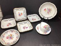 Full lot displaying 4 square reticulated floral dishes, 1 round floral bowl, and Shelley teacup-saucer set
