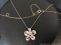 Front view of butterfly pendant on gold chain, displaying clear and pink cubic zirconia stones.