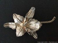 Top down view of the vintage sterling silver flower-shaped brooch showing petal and stem details.
