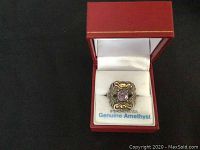 Sterling silver ring with amethyst and marcasite in a red jewelry box showing front view of ring and label "Sterling Silver Genuine Amethyst"