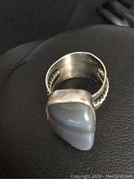 Close-up top-down photo of sterling silver ring showing the genuine agate stone and braided band detail.
