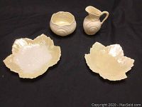 Four pieces green Mark Belleek: cream and sugar containers with snail pattern, two maple leaf-shaped candy dishes.