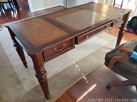 Front-left corner view showing desktop, leather inlays and two side drawers