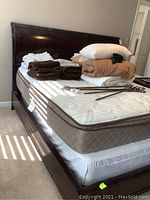 Headboard with stacked bedding showing dark wood finish.