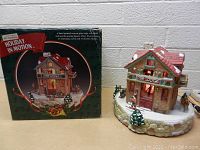 Porcelain Pine Lodge house with box in background showing packaging and branding.