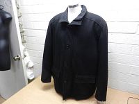 Front view of men's black wool Guess jacket with button closure and two front flap pockets.