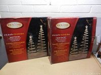 Two boxed sets of Holiday Living Spiral Tree Decorations, showing front packaging with branding and size information.