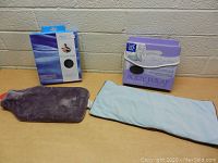 Lot contents showing the hot water bottle with plush gray cover and body wrap in blue fabric with packaging.