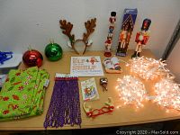 Overview of assorted Christmas items on table including ornaments, nutcrackers, lights, costume accessories, and books.