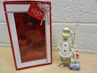 Lenox branded red and white box with clear display window for the ornament