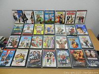 Photo shows 30 assorted DVD movies arranged in rows on a table, displaying cover art of various genres.