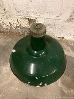 Photo showing top and side view of the dark green metal light fixture with visible paint chips and dirt.