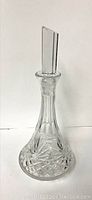 Full view of the clear crystal decanter with stopper with visible chips on the stopper top