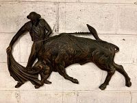 Front view of full wall hanging showing matador with cape and charging bull.