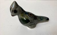 Side perspective of signed Mid Century Modern ceramic bird figurine with visible painted decoration and artist signature.