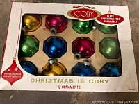 Original box of Coby glass Christmas tree ornaments showing 12 colored balls in packaging with brand and labeling.