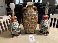 Photo showing two Asian ceramic lamps and one large Satsuma pottery vase on a table.