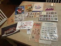 Photo showing multiple vintage cards, catalogs, and printed advertisements including baseball cards, Hall of Fame cartoons, and Dinky Toys catalog.